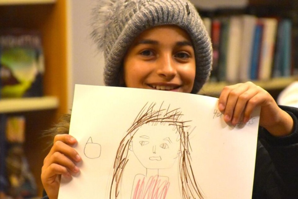 Rama visar upp en teckning hon gjort på After school, Gamlegårdens bibliotek. Rama gick på After school hösten 2020.