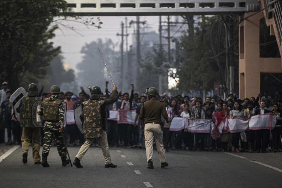 Indisk polis försöker stoppa demonstranter under ett utegångsförbud i Guwahati. Arkivbild.