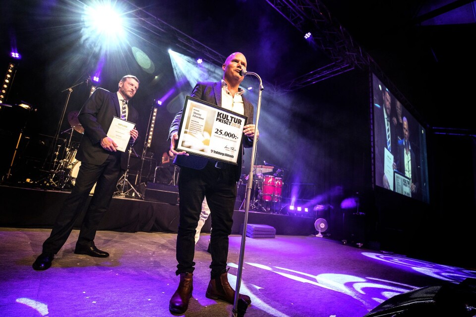 2018 års vinnare av Trelleborgs Allehandas kulturpris, Mattias Edvardsson på scen i Söderslättshallen. I bakgrunden TA:s platschef Bert Westerberg.