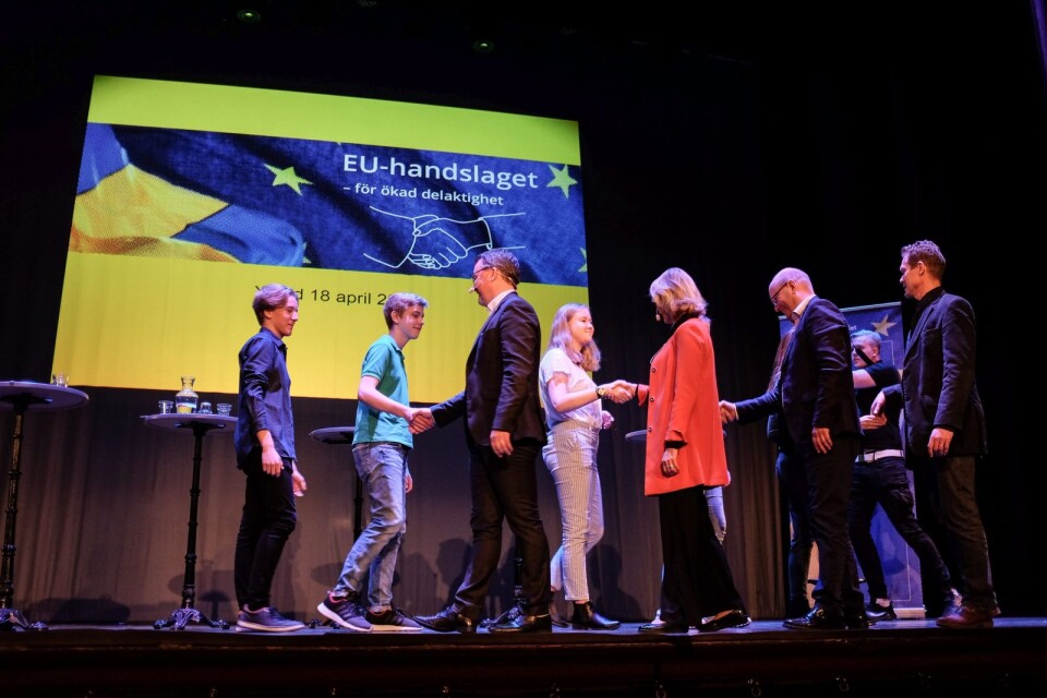 Det officiella EU-handslaget genomfördes 18 april 2018 på Ystad teaters scen, när Leif Sandberg (C), kommunalråd i Tomelilla, Göran Persson (S), ledamot i kommunfullmäktige i Simrishamn, Magnus Weberg (M), kommunalråd i Sjöbo, och Eva Bramsvik Håkansson (C), kommunstyrelsens första vice ordförande i Ystad skakade hand med EU- och handelsminister Ann Linde (S). I samband med det tog alla politikerna i hand med ungdomar från ungdomsfullmäktige och elevråd. Här syns William Schmatz, Tristan Farkas och Maja Sjögren.