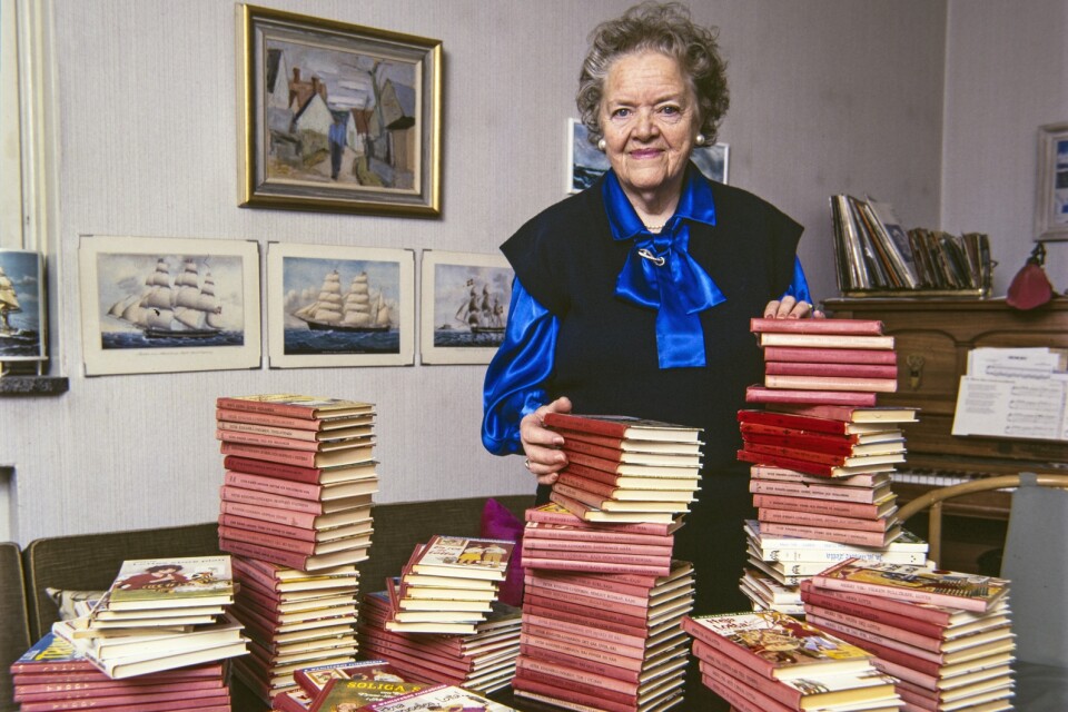 Författaren Ester Ringnér-Lundgren är mest känd för sina barnböcker Lotta Månsson som hon skrev under pseudonymen Merri Vik. Här ses hon i sitt vardagsrum med några av dessa Lotta-böcker.