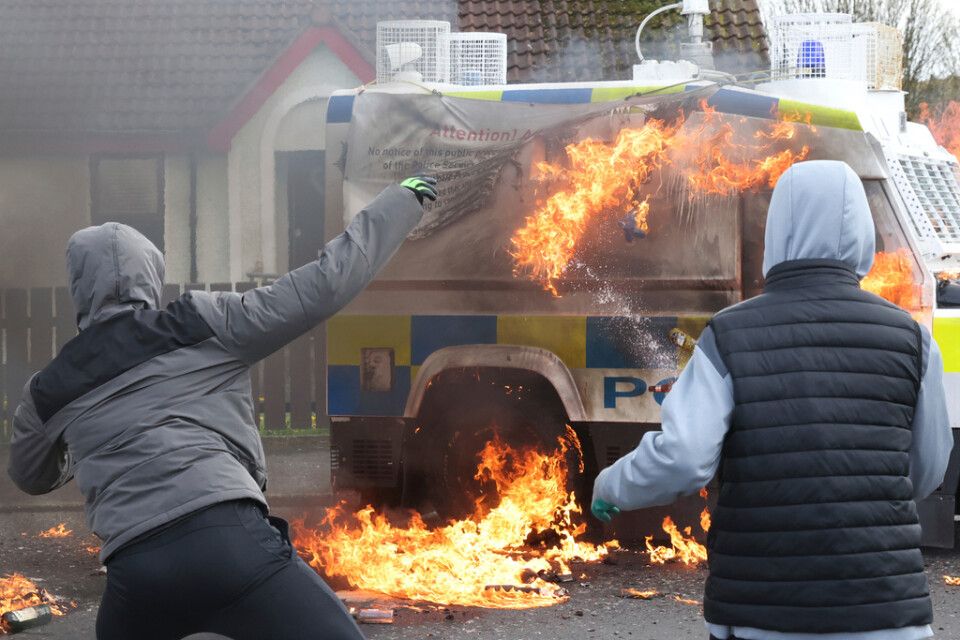 Maskerade ungdomar kastar bensinbomber mot polisfordon i Derry i Nordirland.