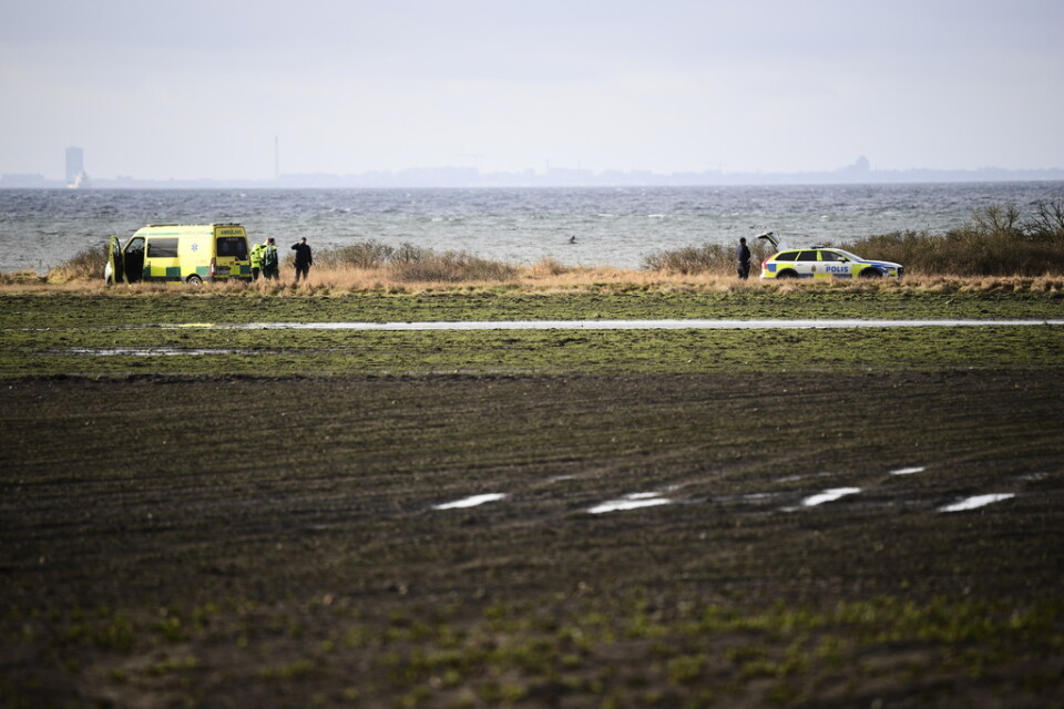Polis och ambulans på fyndplatsen vid Lundåkrabukten söder om Landskrona där en död person hittades.
