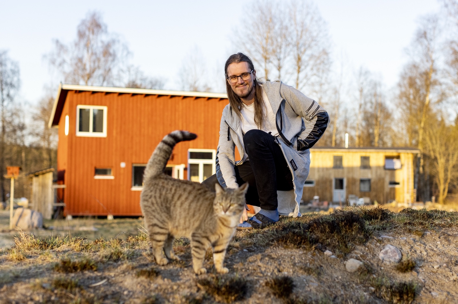 Agust Helgason med katten Nala utanför deras hem.