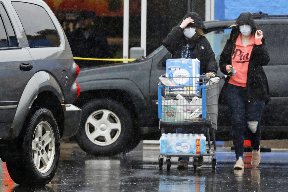 Två personer bär ansiktsmasker på grund av virusutbrottet vid besöket på detaljhandelskedjan Walmart i USA.