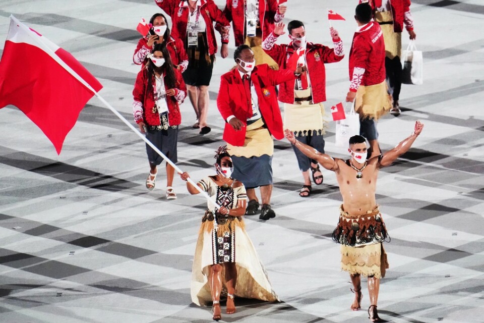 Pita Taufatofua, höger, och Malia Paseka, vänster, när Tonga tågade in på Olympiastadion i Tokyo.