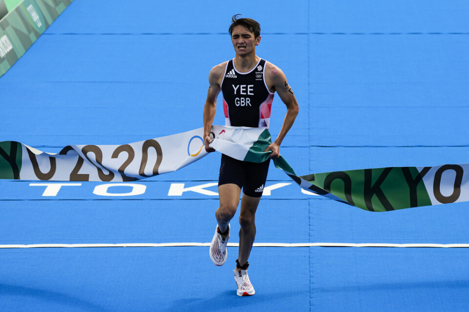 Alex Yee springer i mål i triathlons mixedstafett.