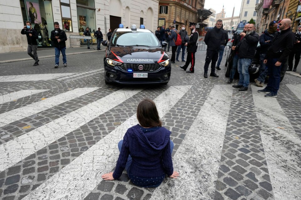 På bilden syns en aktivist från Extinction Rebellion som blockerar vägen i samband med en demonstration utanför ett G20-möte i Rom, Italien i helgen.