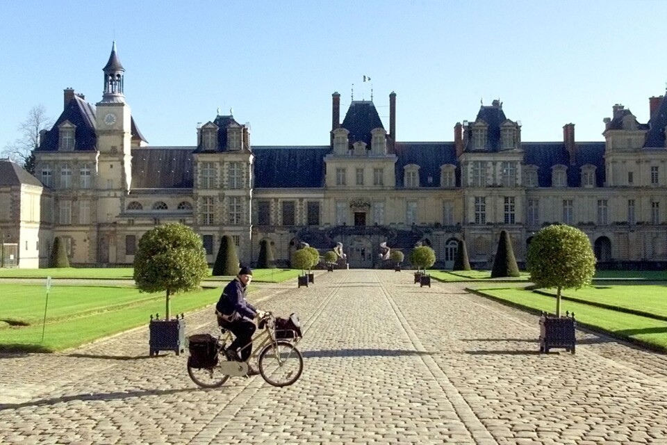 En brevbärare cyklar förbi slottet Fontainebleau, utanför Paris.