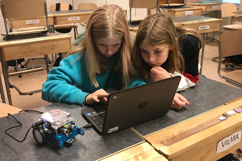 Emilia Vadaszi och Isabelle Hermansen talar om för roboten vad den ska göra. Det gör de genom att skriva en kod som överföras till roboten.