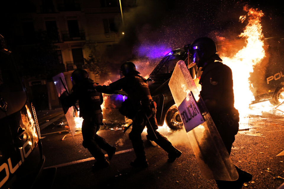 Poliser springer undan när en polisbuss fattar eld vid protesterna i Barcelona.