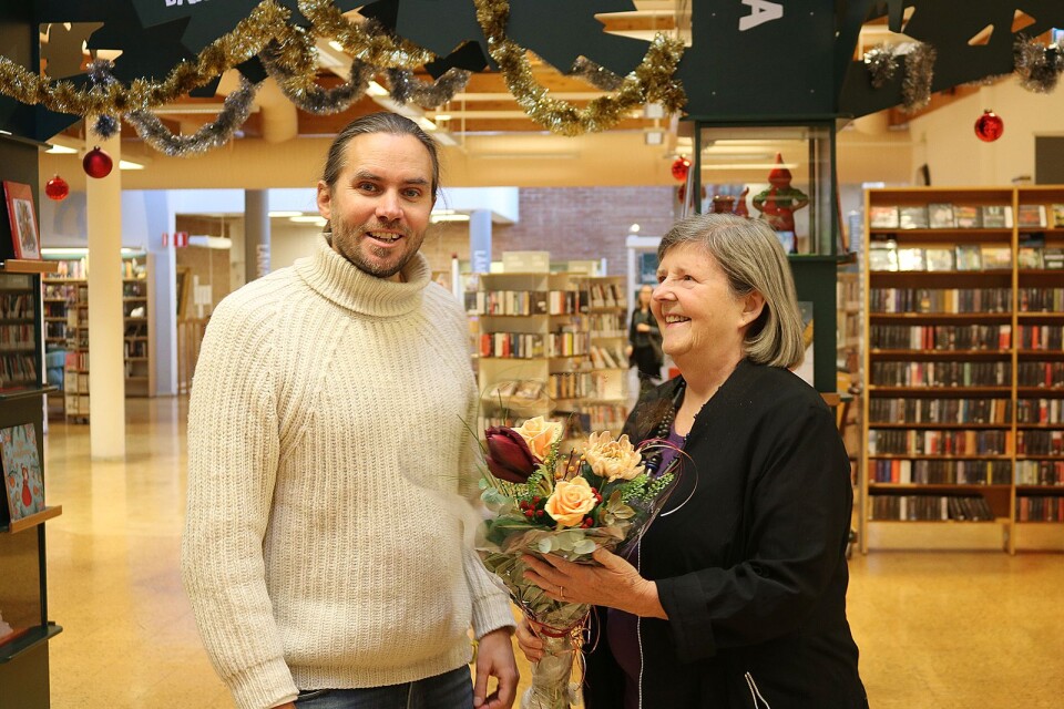 Pav Johnsson tar emot blommor och gratulationer av Catharina Lindencrona, tidigare ordförande i Ölandsklubben i Stockholm, när hon berättar att han är mottagare av 2018 års Stora pris som delas ut av klubben.