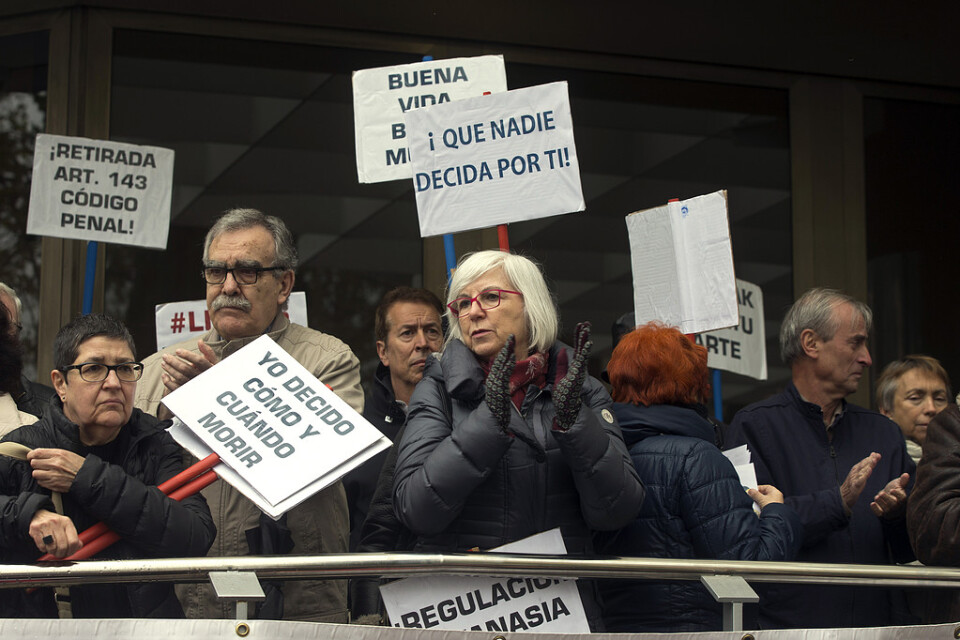 Människor utanför en domstol i Madrid som demonstrerar för en legalisering av dödshjälp.