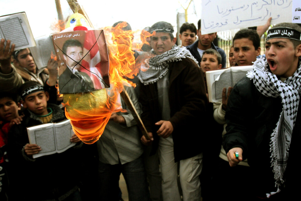 Palestinska barn och ungdomar sätter eld på en bild av Danmarks dåvarande statsminister Anders Fogh Rasmussen i Gaza den 13 februari 2006. Arkivbild.