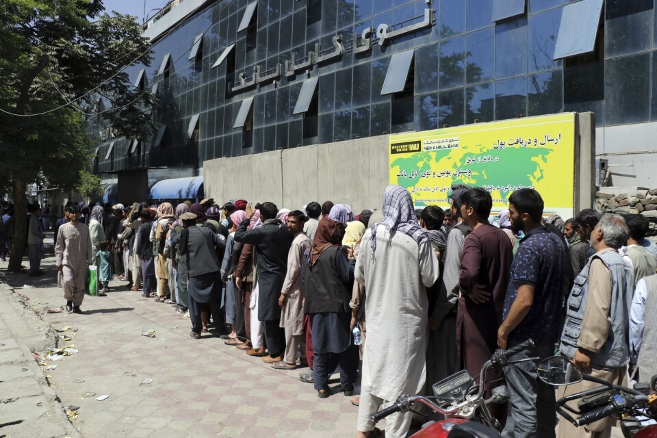 En lång kö ringlar utanför Bank of Kabul i Afghanistan. Sedan Talibanernas maktövertagande finns en uttagsgräns på 200 dollar per vecka. Arkivbild från köer 25 augusti 2021.