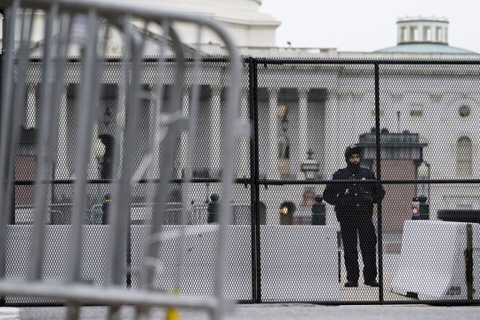 En polisman vaktar ett avspärrat Kapitolium i Washington DC, efter stormningen förra veckan. Nödläge har utlysts i staden inför Joe Bidens installation den 20 januari.
