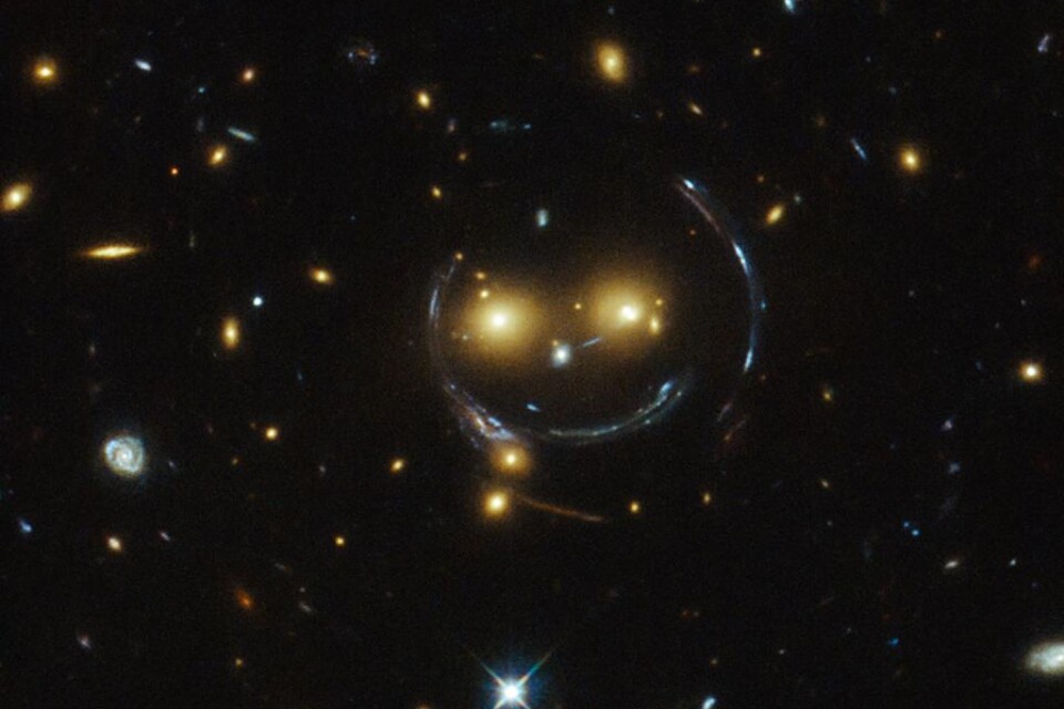 En galax långt, långt borta ler ner mot oss. Det är rymdteleskopet Hubble har fångat galaxhopen med namnet SDSS J1038+4849, en jättelik rymdsmiley. Det som ser ut som ett leende ansikte är i själva verket två avlägsna galaxer, rapporterar SVT. Ögonen är