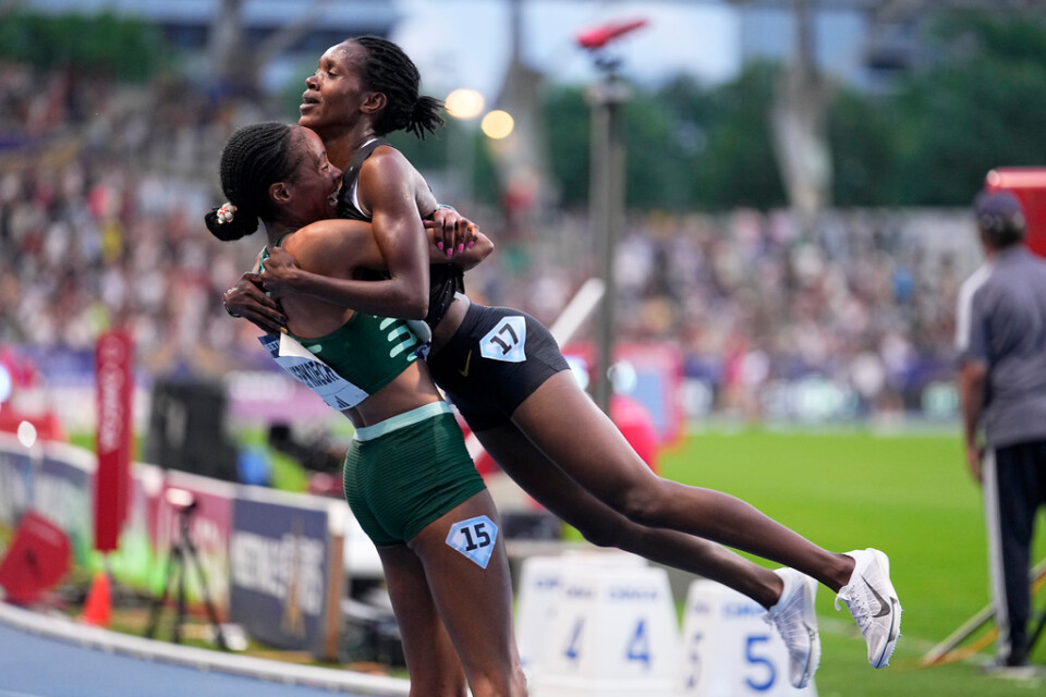 Faith Kipyegon, Kenya, hissas upp i luften av landsmaninnan Beatrice Chepkoech, till vänster, efter världsrekordet på 5|000 meter.