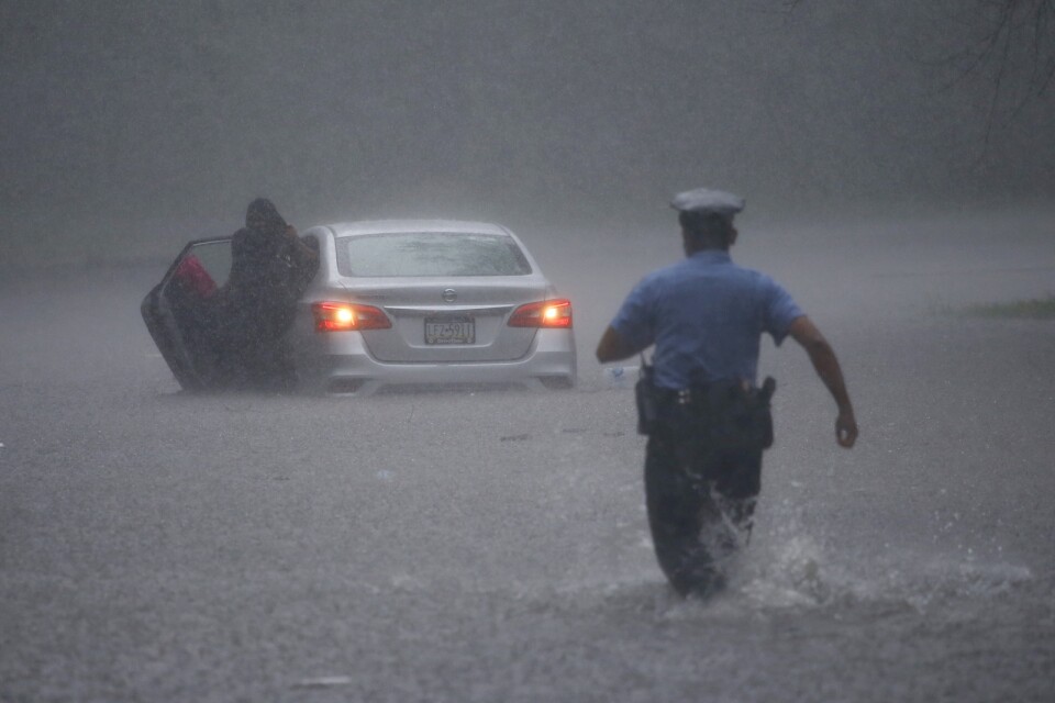 Polis rycker ut för att hjälpa en bilist som fastnat i vattenmassorna i Philadelphia.