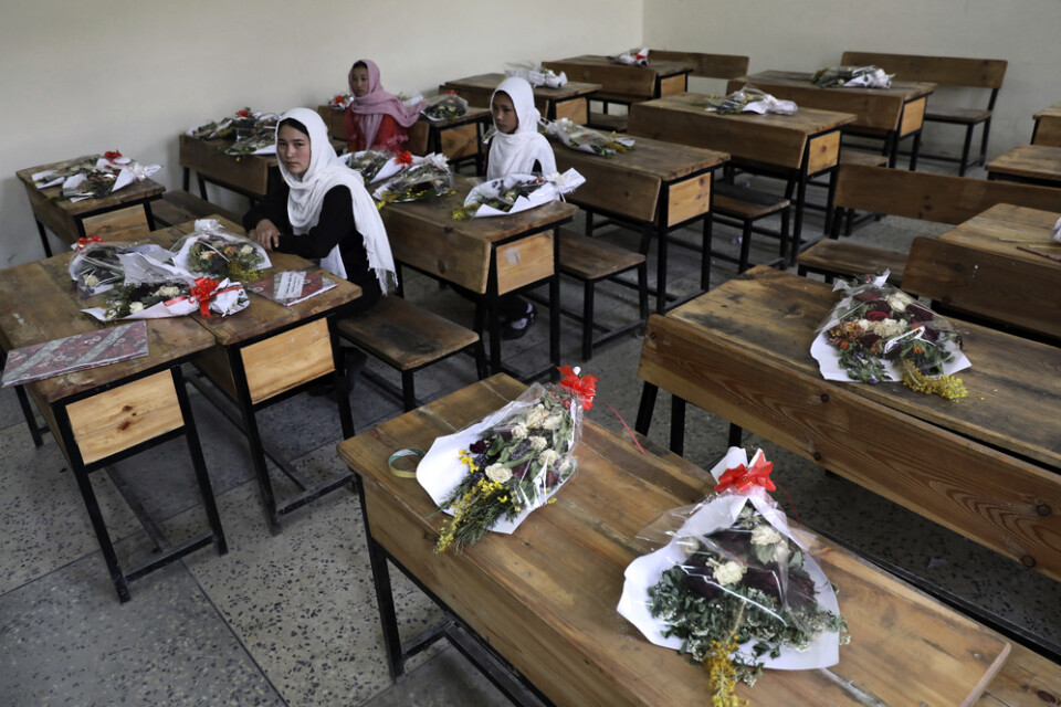 Flickor i en skola i Afghanistans huvudstad Kabul med blommor på de bänkar där klasskamrater som dödats suttit. Arkivbild.