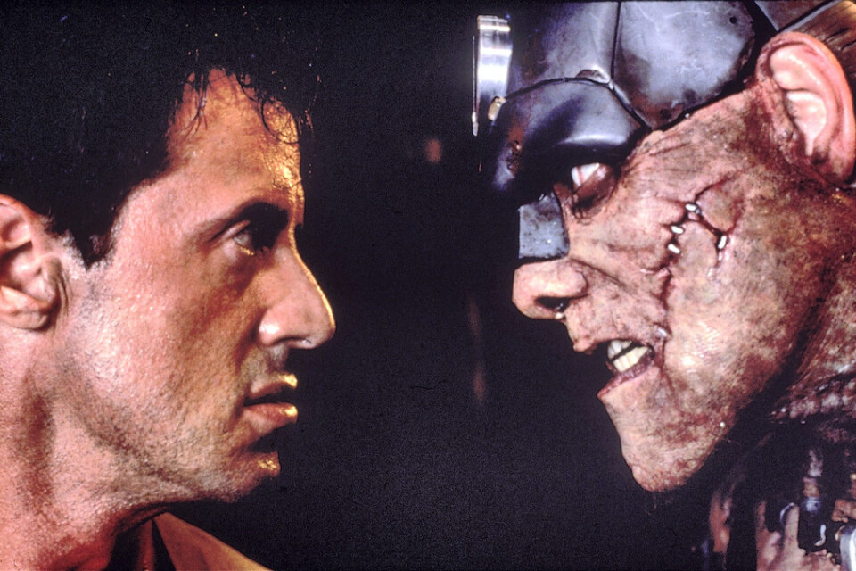 Sylvester Stallone som polismannen Judge Dredd i en postapokalyptisk framtid. Här möter han en inavlad kannibal-cyborg utanför megastadens höga murar. Pressbild.
