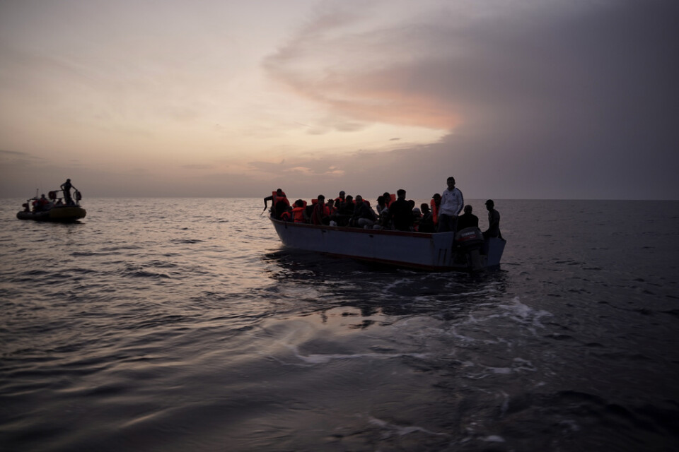 Migranter på en överfull båt på Medelhavet väntar på att bli räddade.