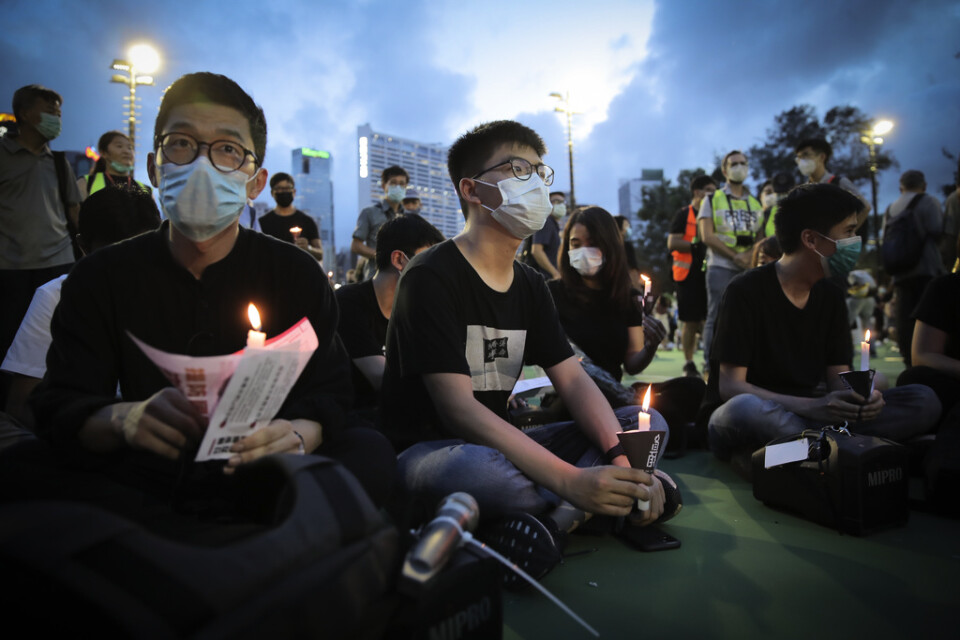 Den framträdande demokratiaktivisten Joshua Wong (mitten) är en av de som samlats för ljusmanifestationen för massakern på Himmelska fridens torg.