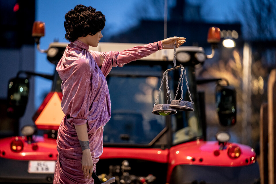 En docka föreställande "Fru Justitia" var uppställd på ett släp bakom en traktor utanför rättslokalen i Köpenhamn.