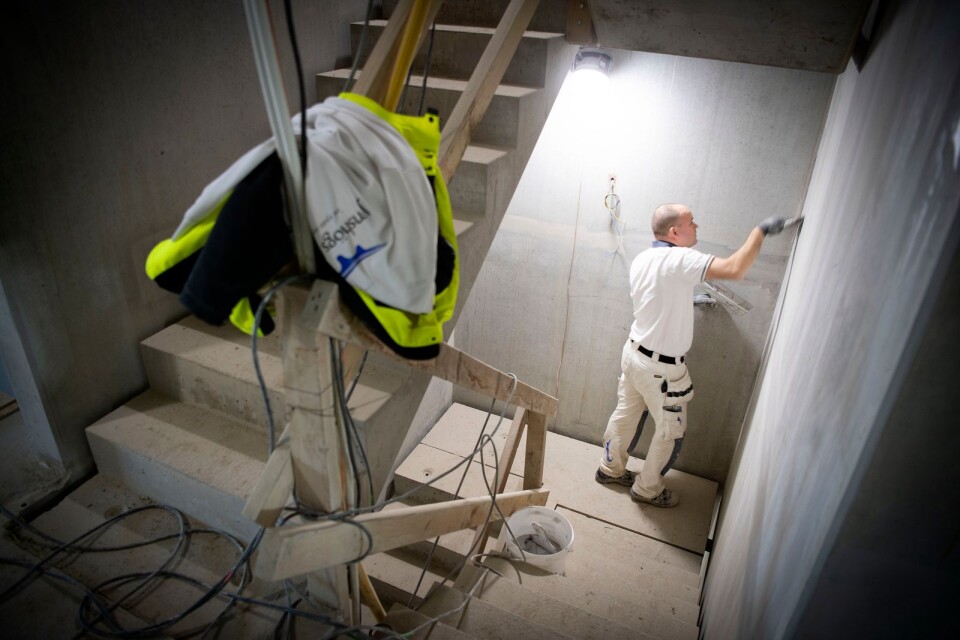 Markus Bengtsson spacklar väggarna i den framtida trappuppgången.