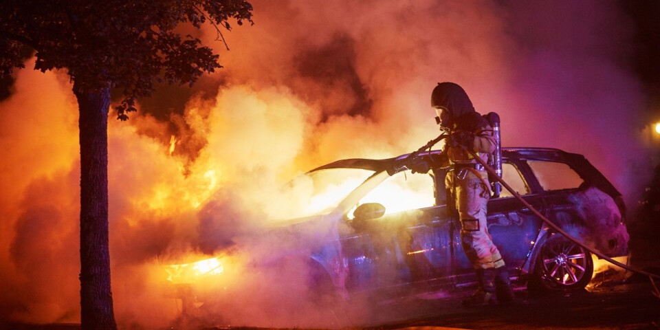 En brandman släcker en brinnande personbil. Arkivbild.