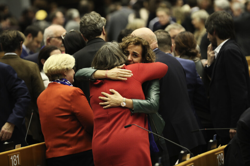 Brexitsörjande EU-parlamentsledamöter kramar om varandra efter att ha röstat om att godkänna Storbritanniens utträdesavtal.