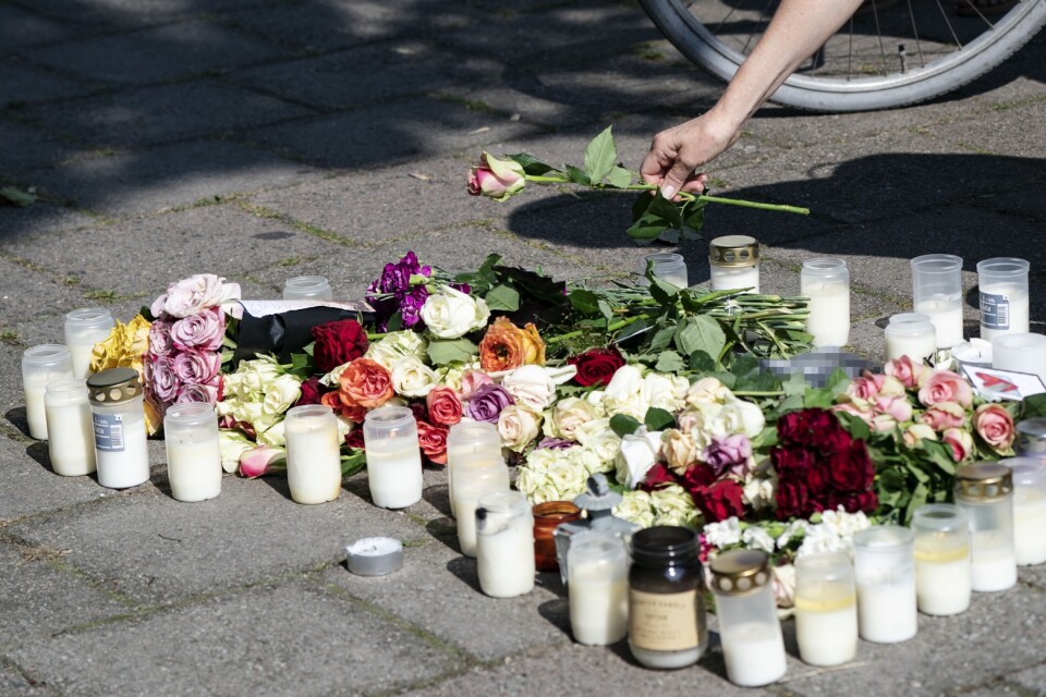 En kvinna lägger ner en ros vid minnesplatsen på Sergels väg i stadsdelen Ribersborg i Malmö där en 30-årig kvinna skjutits till döds föregående dag. Arkivbild.