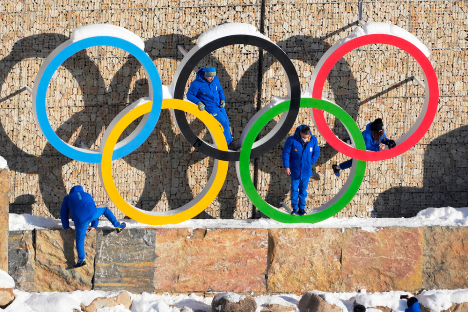 Personer ur den ukrainska OS-truppen poserar vid OS-ringarna i OS-byn i Yanqing i Kina.