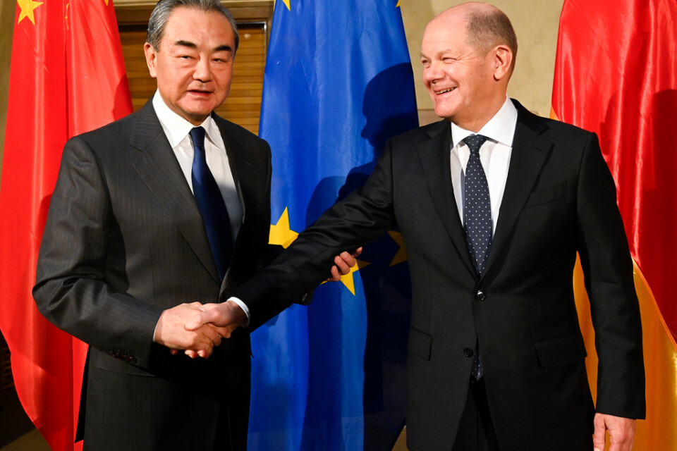 Wang Yi skakar hand med Tysklands förbundskansler Olaf Scholz vid säkerhetskonferensen i München i februari. Arkivbild.