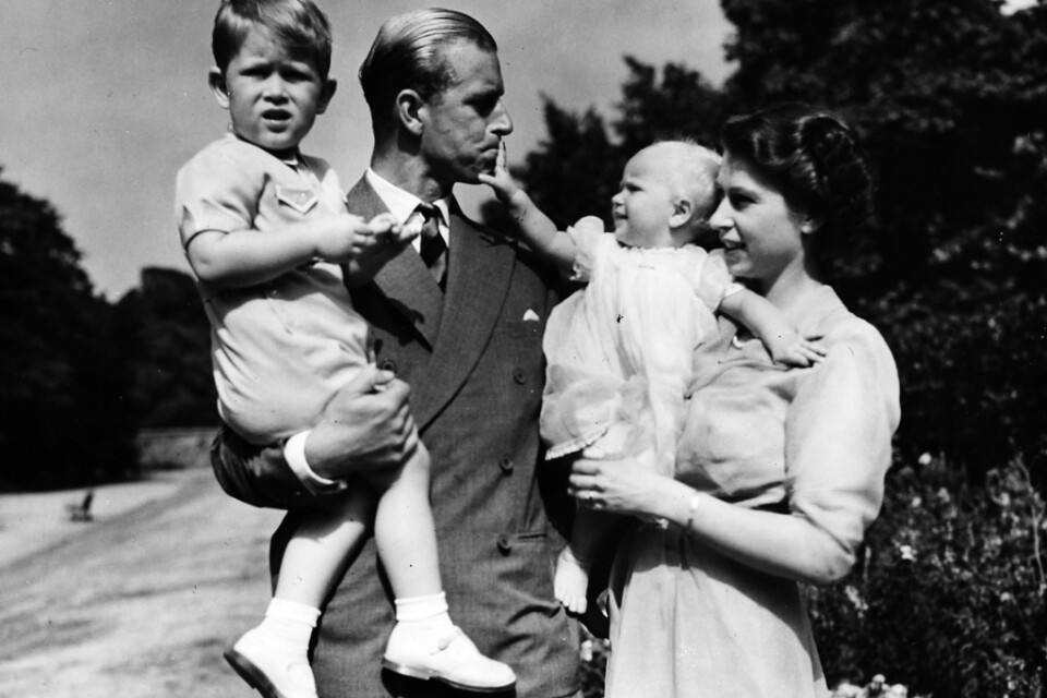 Charles i pappa Philips famn 1951, då han snart skulle fylla tre år. Till höger mamma Elizabeth och lillasyster Anne.