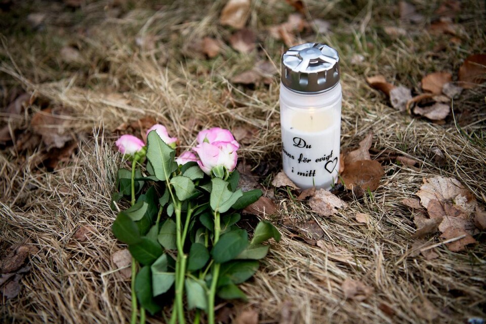 Blommor och tända minnesljus var på fredagen placerade vid platsen för det dödliga våldsdådet i Olofström. Foto: gunnel persson