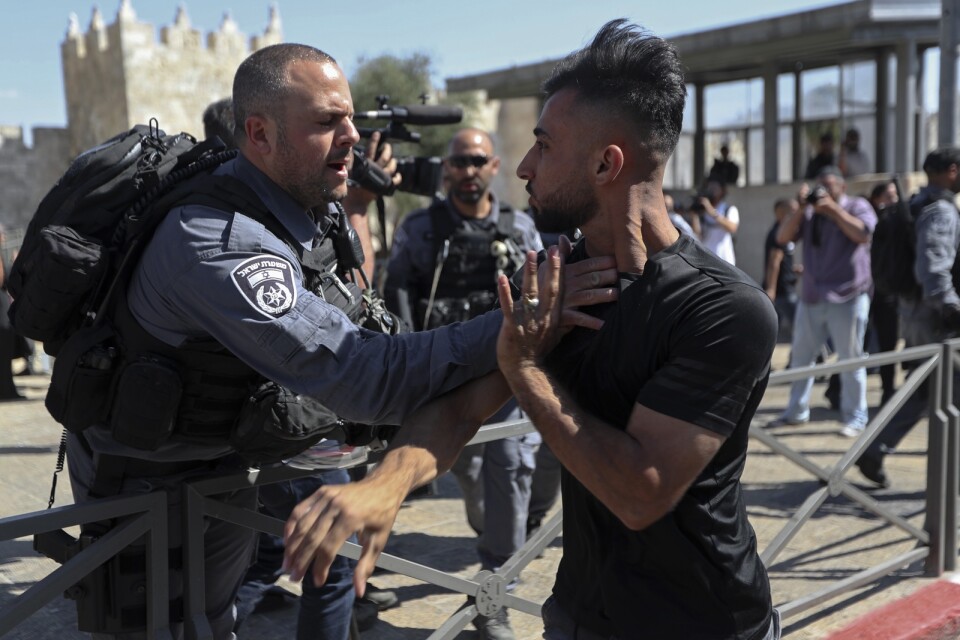 En palestinsk man avvisas av israelisk polis nära Damaskus-porten där tisdagens marsch senare passerade.