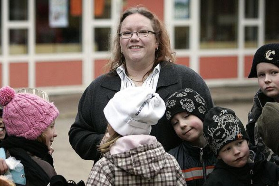 Genuspedagogen Anita Spjuth omgiven av barn.