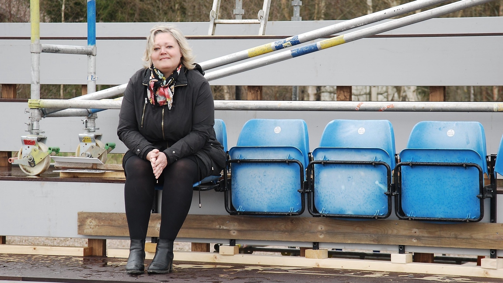 Sportchefen Erika Nilsson testar en provisoriskt uppsatt sittplats. När läktaren är klar kommer den att rymma 168 platser – alla under tak.