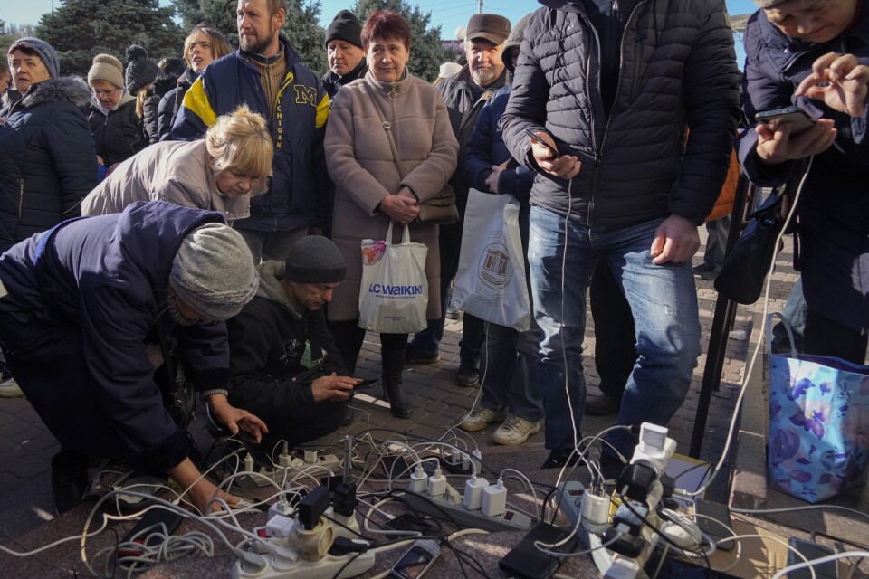 Tio miljoner ukrainare saknar nu elektricitet i sina hem. Invånare i Cherson tvingades ladda sina telefoner på ett torg på tisdagen.
