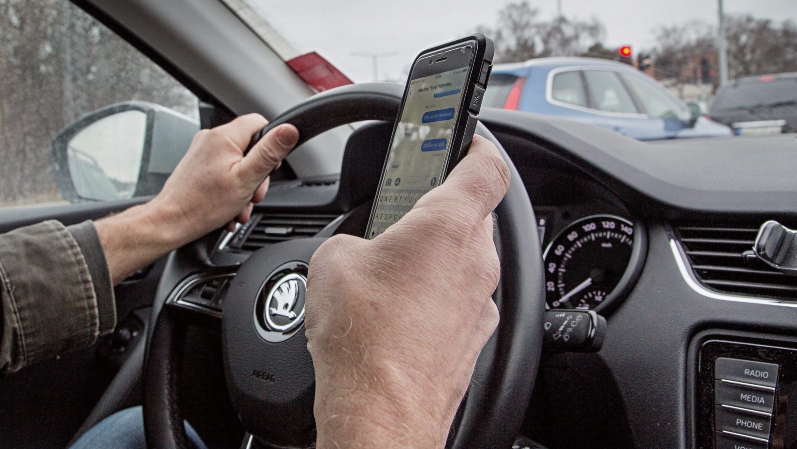 Person kör bil och håller i mobiltelefon samtidigt.Foto: Fotograferna Holmberg / TT / kod 96