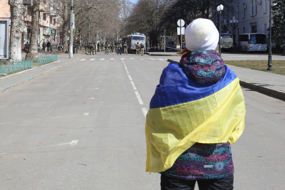 En kvinna i Cherson insvept i en ukrainsk flagga protesterar mot den ryska ockupationsmakten. Bilden är tagen 19 mars.