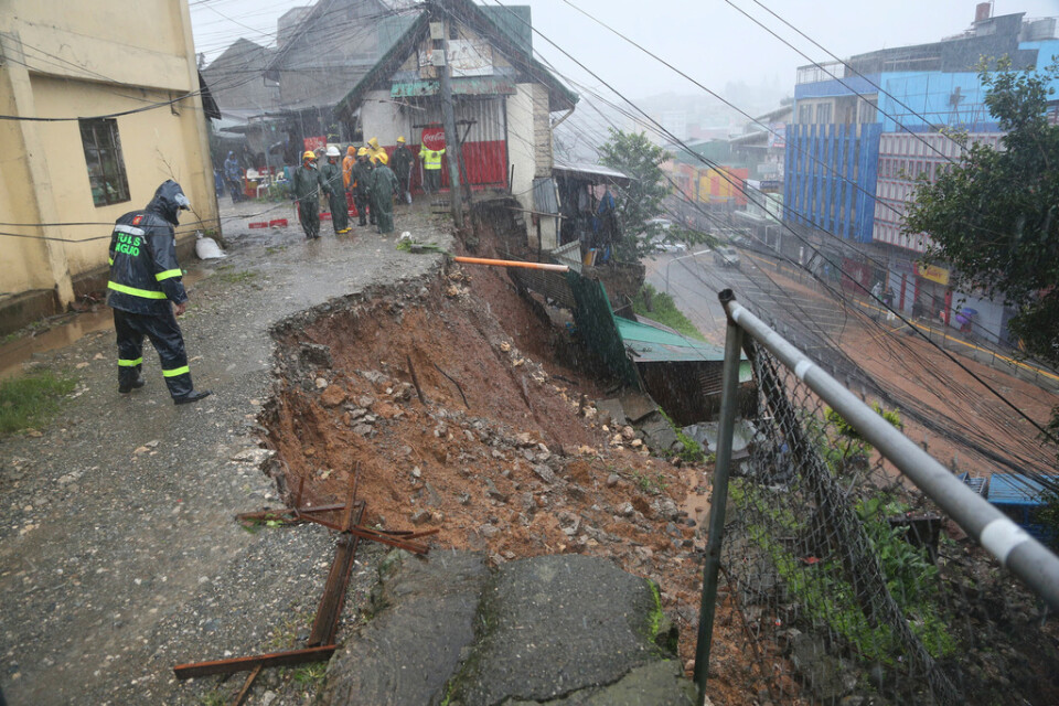 En polis kontrollerar ett jordskred som orsakats av tyfonen Doksuri i Baguio City i norra Filippinerna på onsdagen.