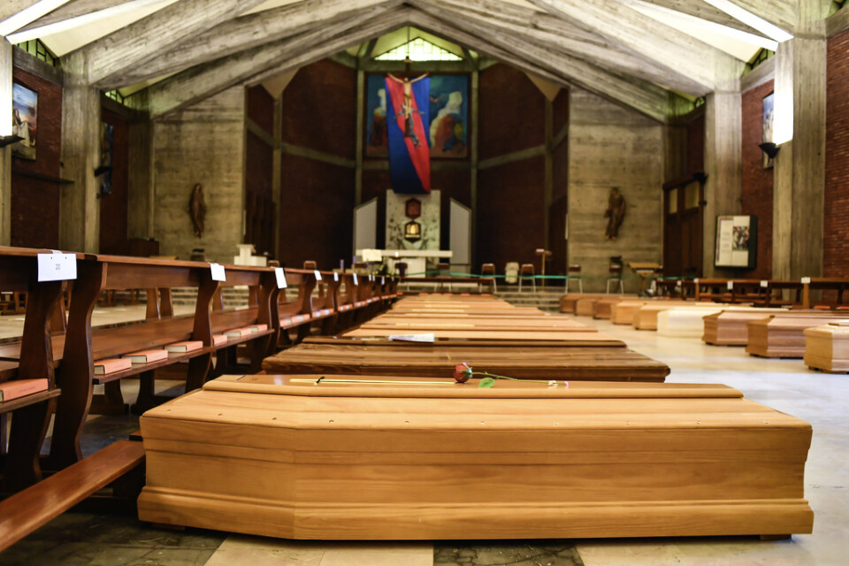 Kistor som ska vidare till ett krematorium ligger på golvet i San Giuseppe-kyrkan Seriate i provinsen Bergamo i Italien.
