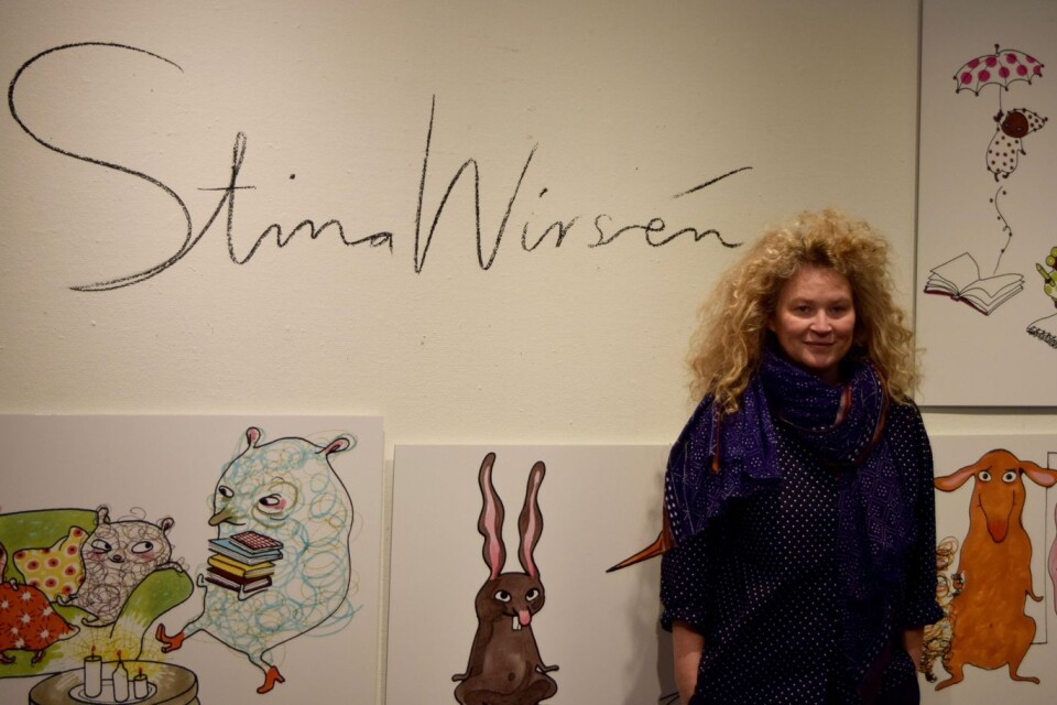 Stina Wirsén med några av sina illustrationer på Skurups bibliotek.