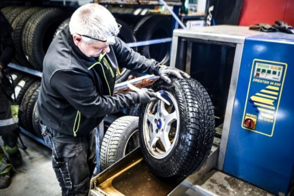 Ingvar Nilsson brushes the rims on a tyre that has been rinsed-off in the tyre washer