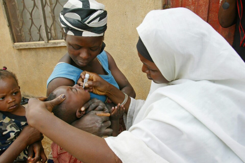 Frivilligarbetare för en muslimsk hälsoorganisation i Nigeria i färd med ge ett barn vaccin i form av droppar i munnen. Coronapandemin gör det svårare att nå ut till de som är i störst behov av hjälp att motverka sjukdomar.