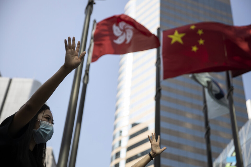En demonstrant i Hongkong håller upp sin hand med sina fem fingrar som en symbol för de fem krav som demonstranterna ställt på Hongkongs regering.