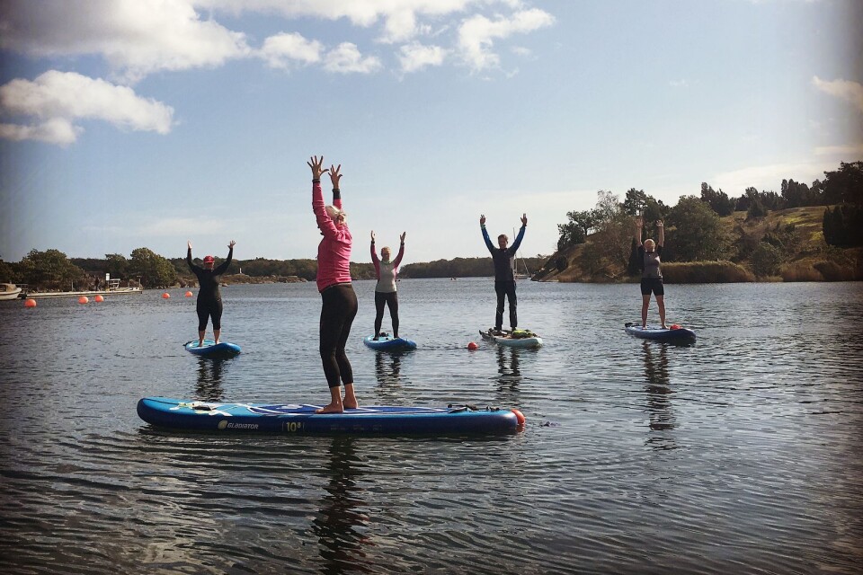 Här provar deltagare yoga på stand up paddle.