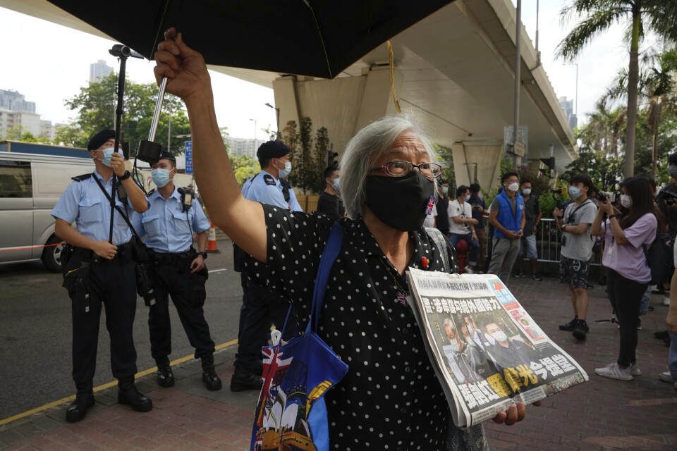 Demonstranter protesterar utanför domstolen i Hongkong till stöd för två chefer vid den prodemokratiska tidningen Apple Daily.